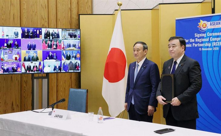 RCEPの首脳会合がテレビ会議方式で開かれ、協定の署名式に出席した菅首相(左)と梶山経産相(内閣広報室提供)