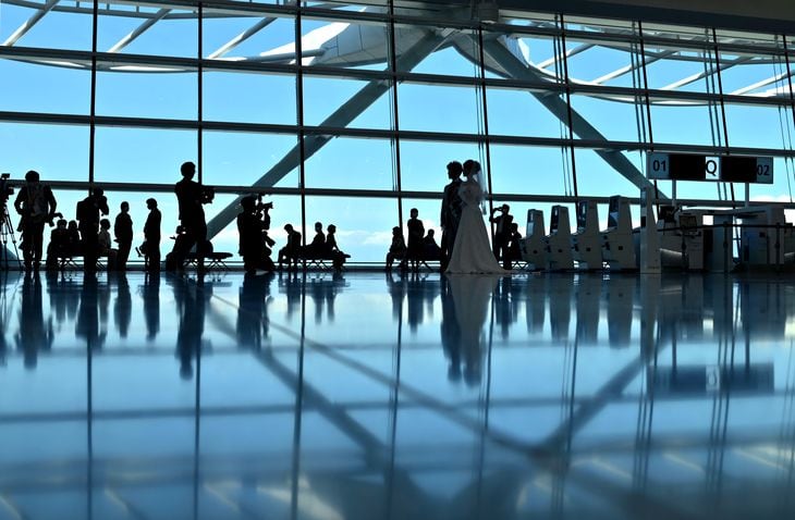 コロナ禍で減便が続く国際線の旅客機で結婚式のサービスが始まった。新郎新婦は国際線出発ロビーで参列者やスタッフに迎えられた =羽田空港(宮崎瑞穂撮影)