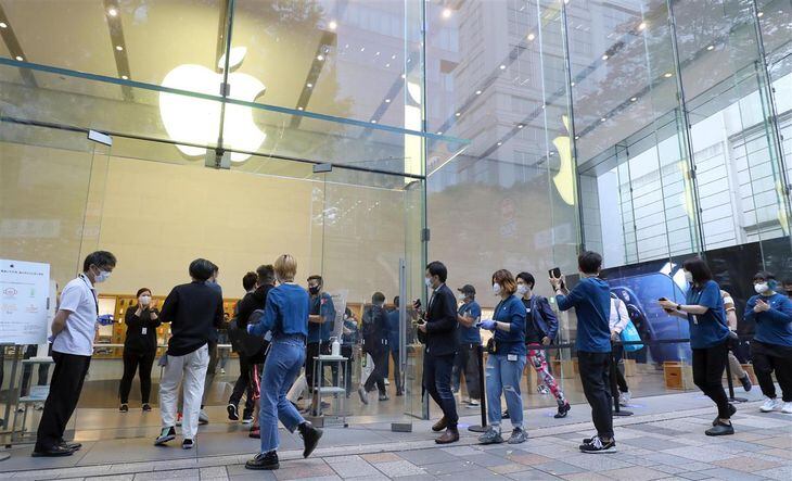 iPhone 12が発売されスタッフの拍手を受けながらApple 表参道に入る人々=23日午前、東京都渋谷区(萩原悠久人撮影)